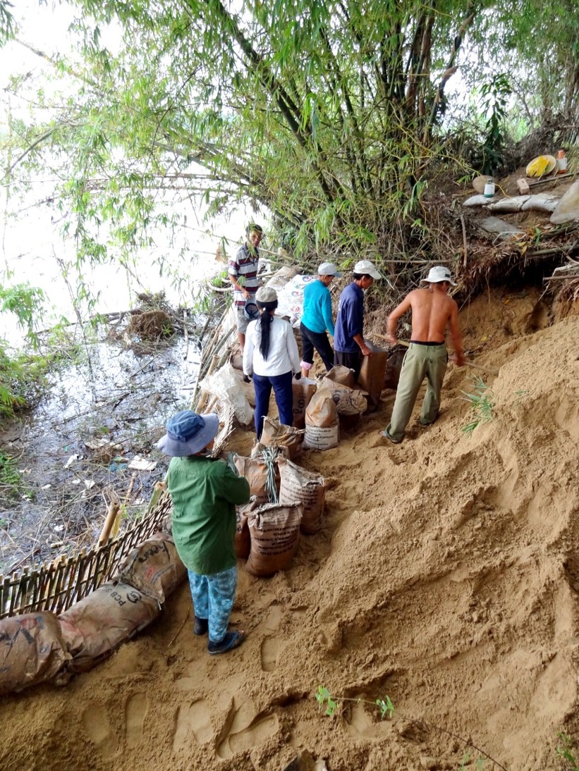 Villagers reinforcing the riverbank with sandbags