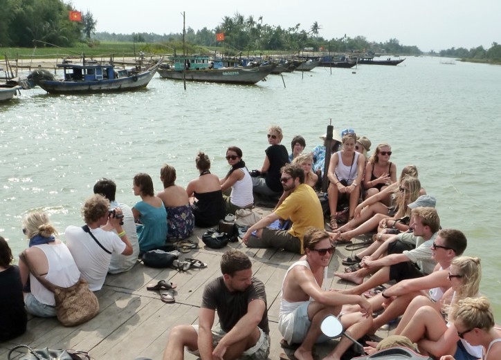 Guests gathered on a riverside deck overlooking the Thu Bồn