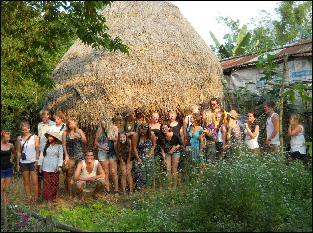 Group portrait of guests in front of a traditional haystack