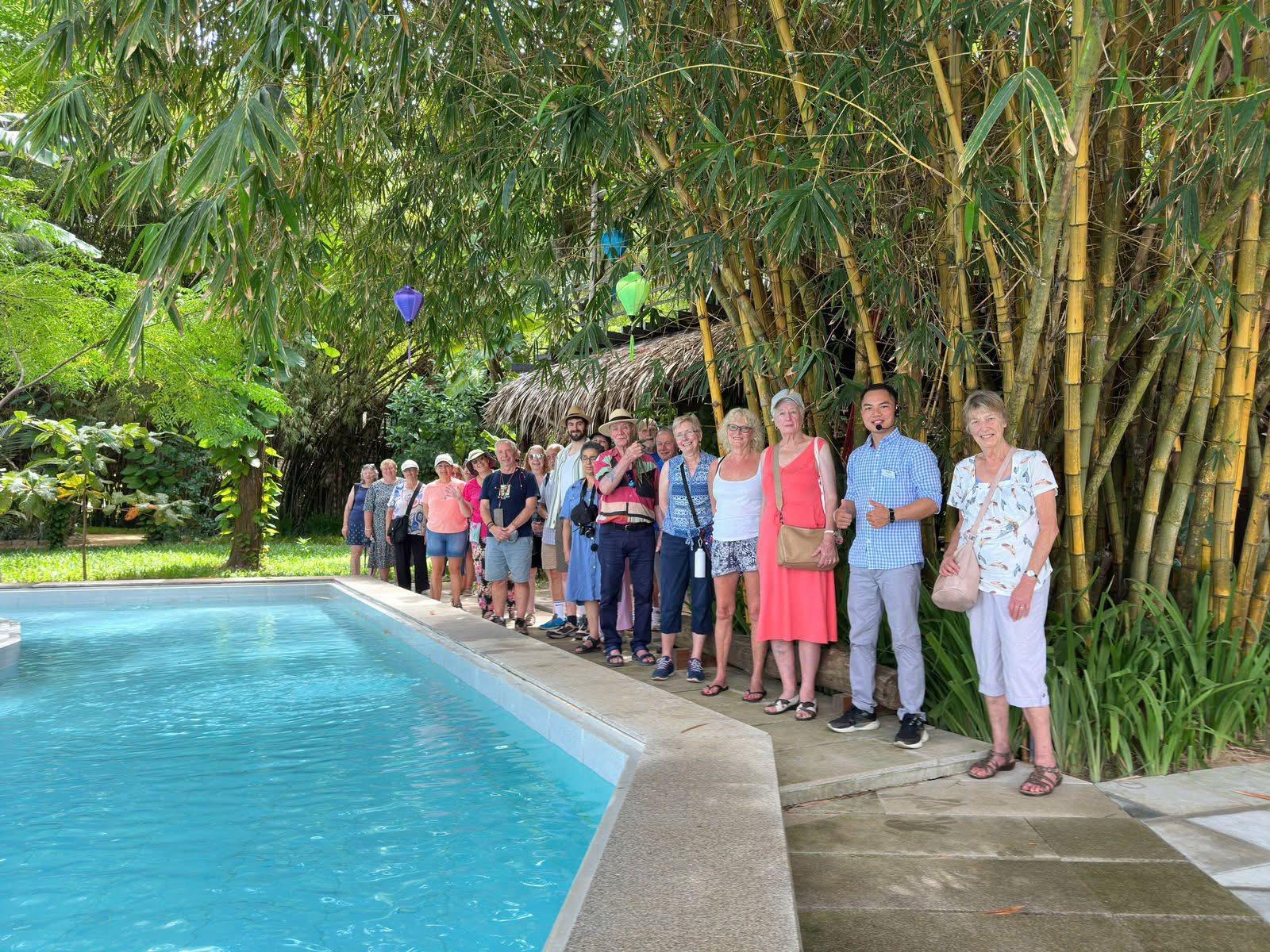 Guests gathered by the poolside under bamboo