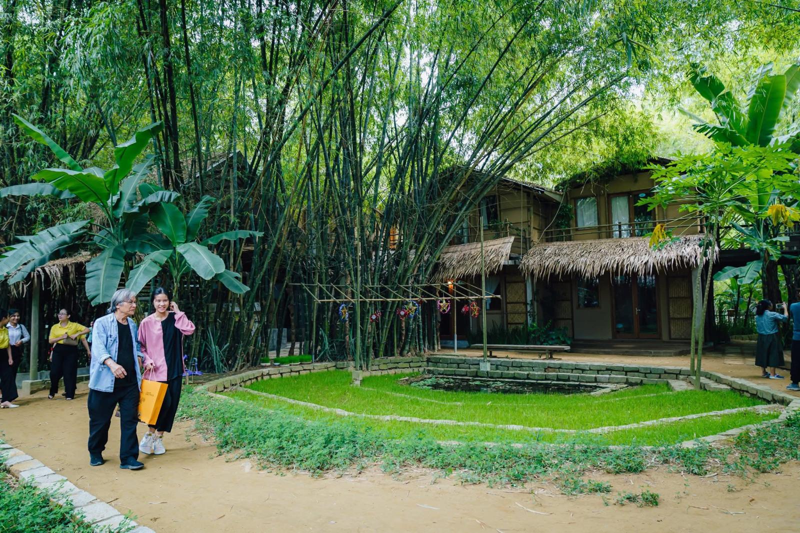 Guests walking through the bamboo grove by the lotus pond