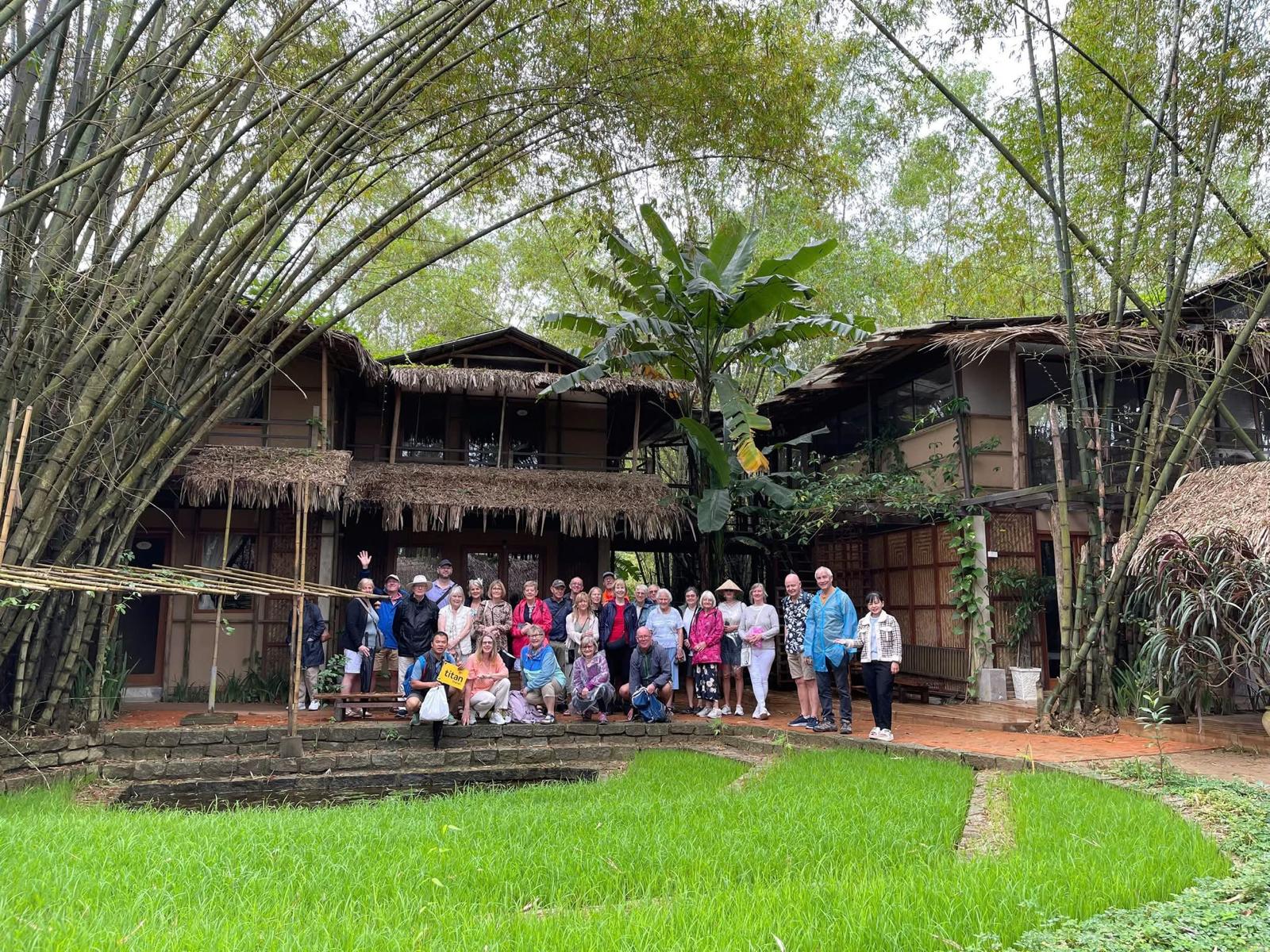Guest group under the bamboo arch with rice paddies