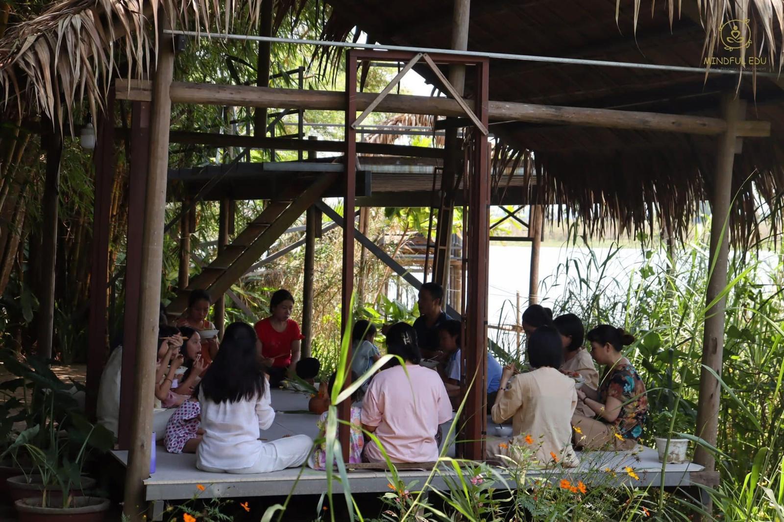 Shared meal at a riverside bamboo pavilion