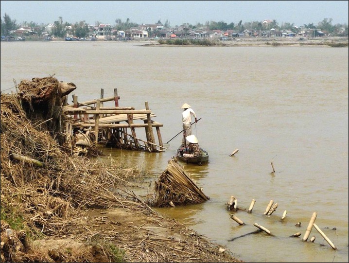 Eroded riverbank with collapsed bamboo structures
