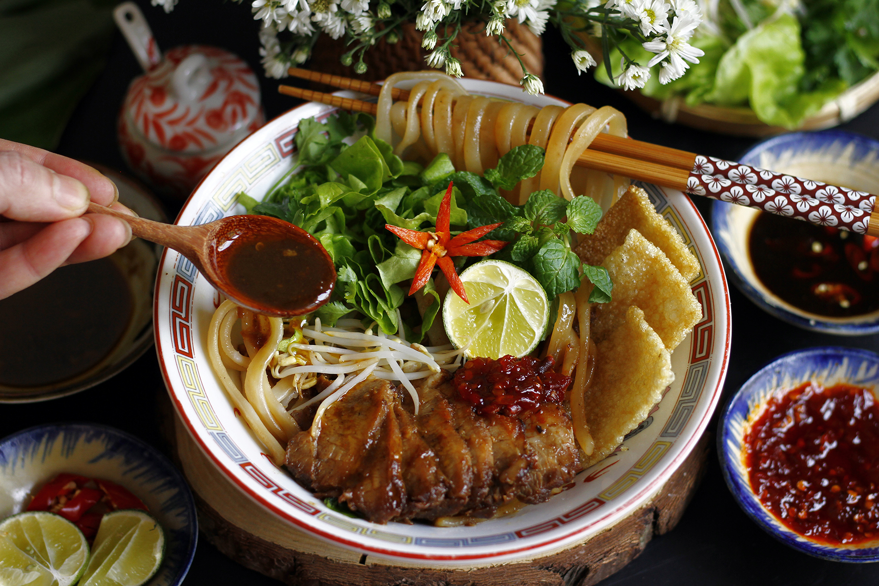 Bowl of Cao Lầu noodles on a wooden table