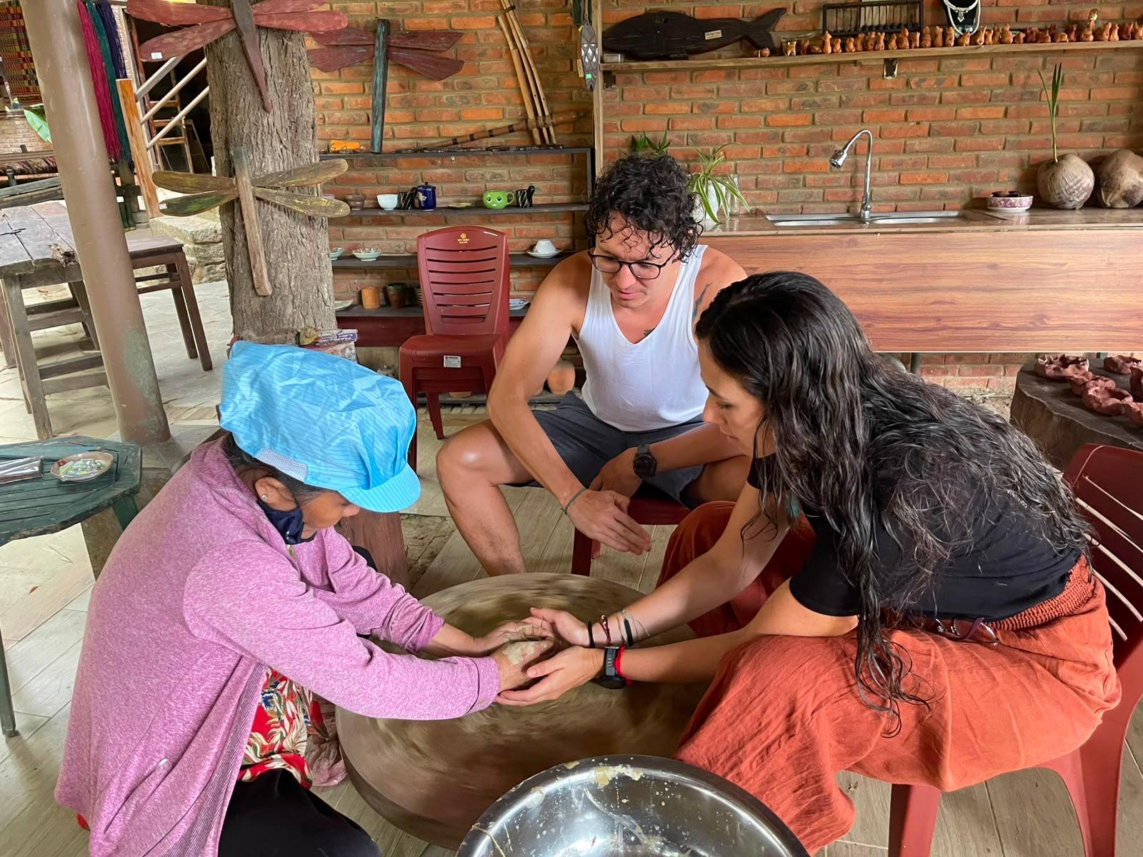 Guests shaping clay with the village ceramicist at the pottery wheel