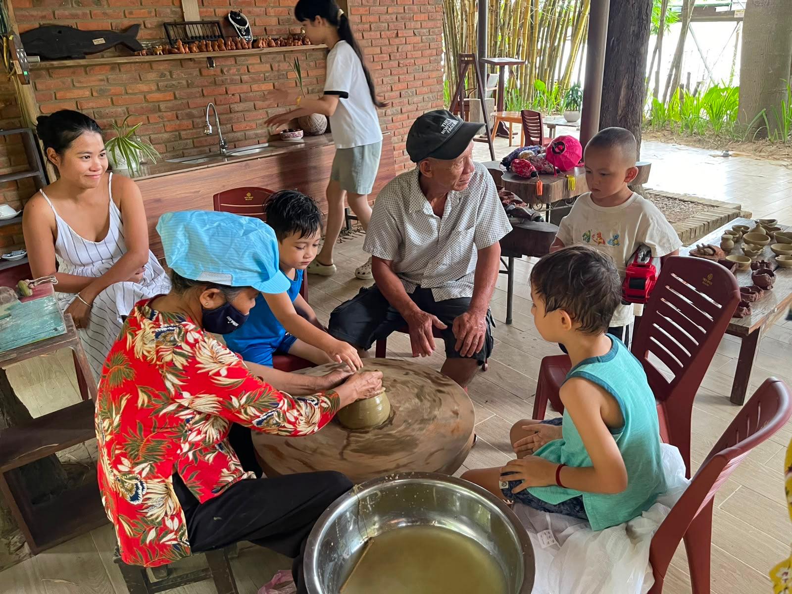 Children and elders gathered around the potter's wheel