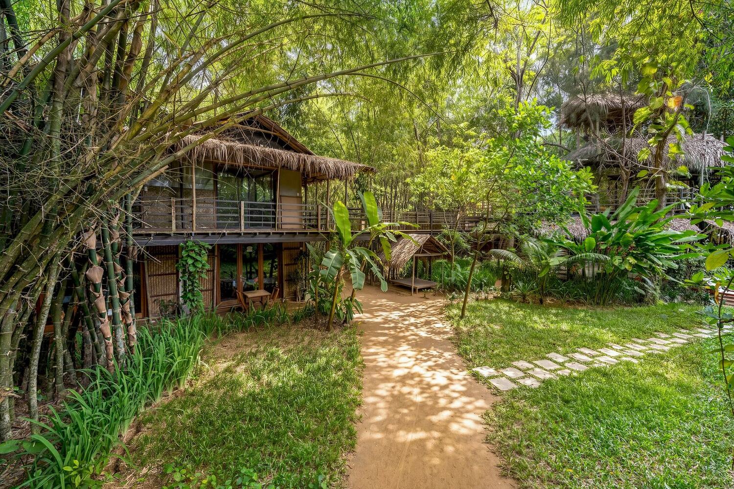 A path through the garden between the bamboo houses