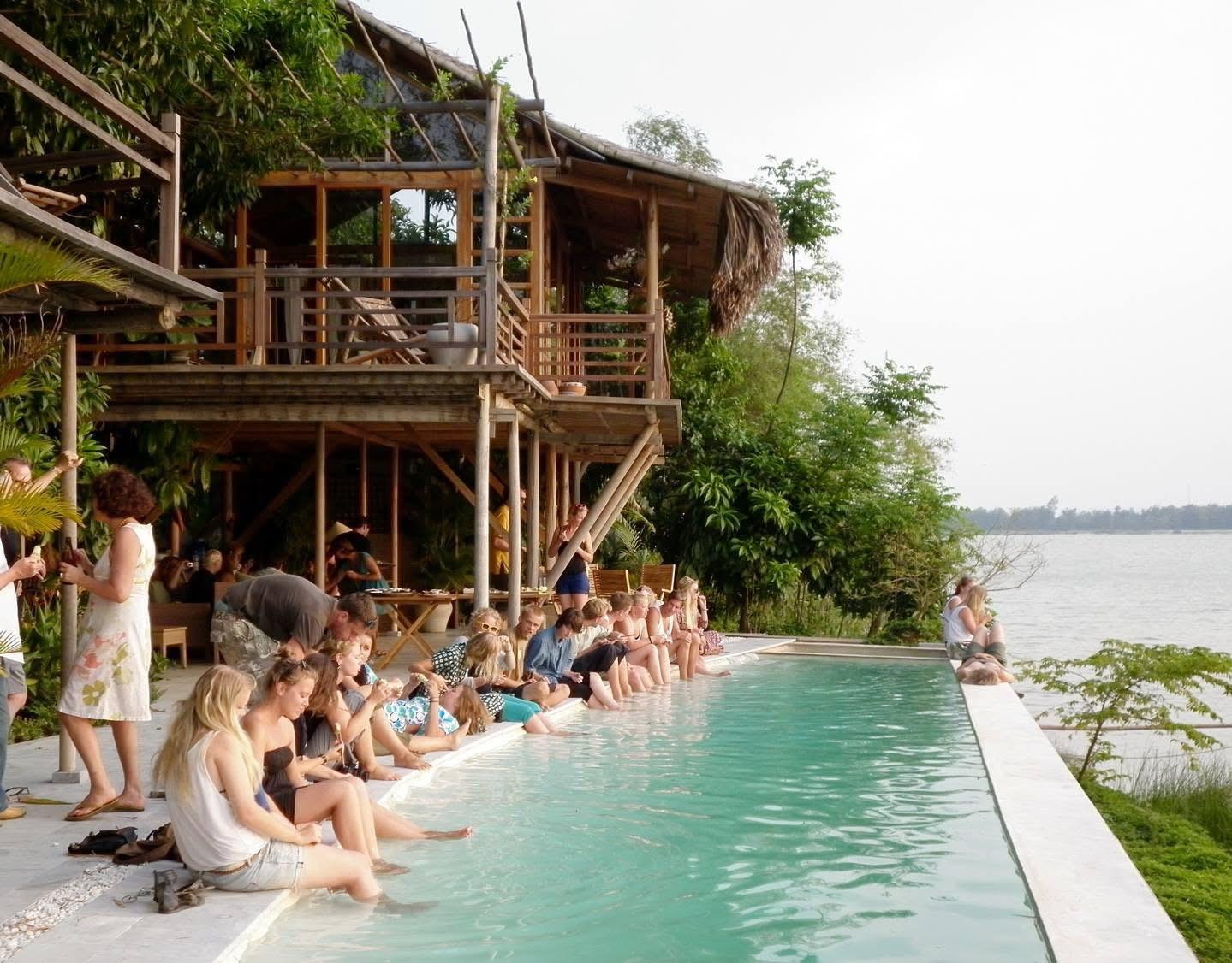 Guests dipping their feet in the riverside infinity pool