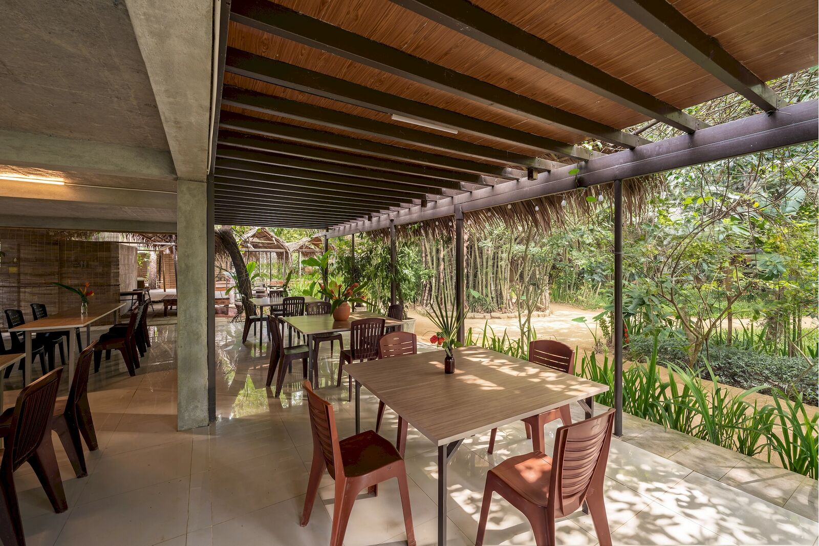 Open-air restaurant tables under the timber roof