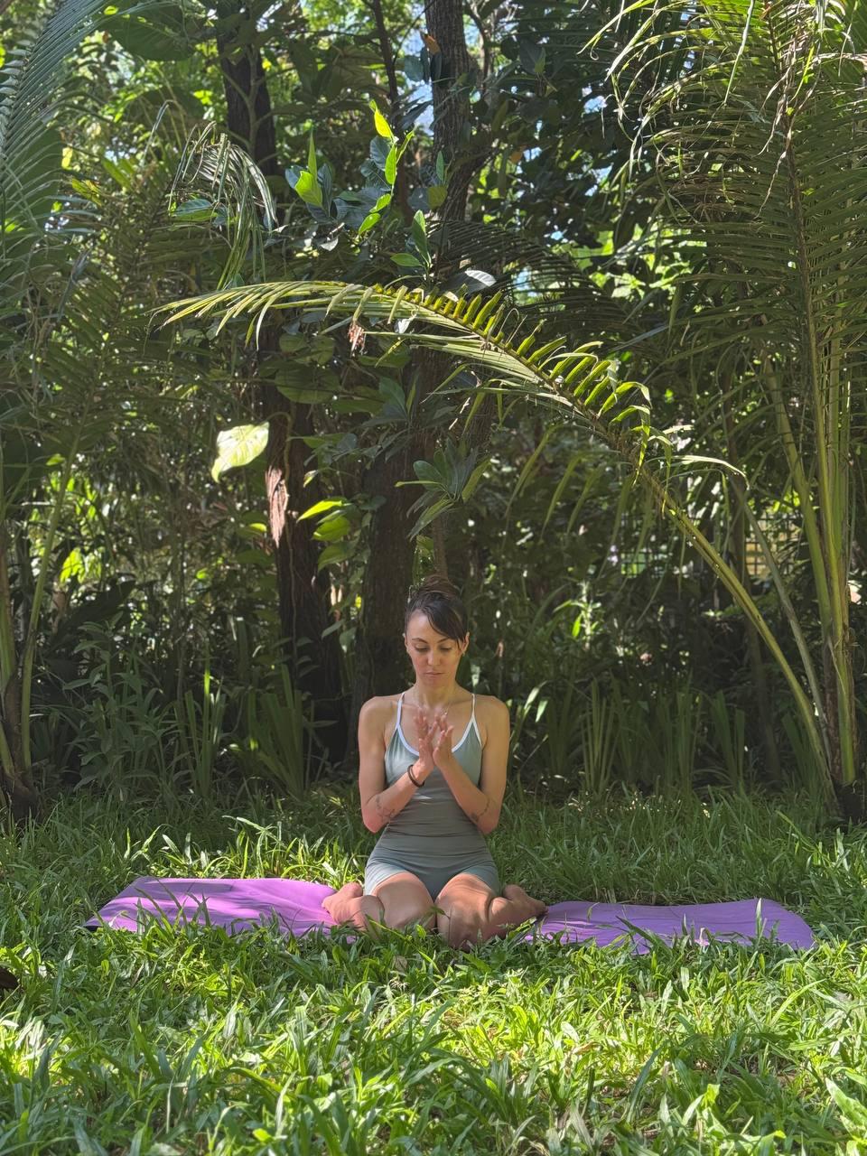Seated meditation in tall grass beneath the palms