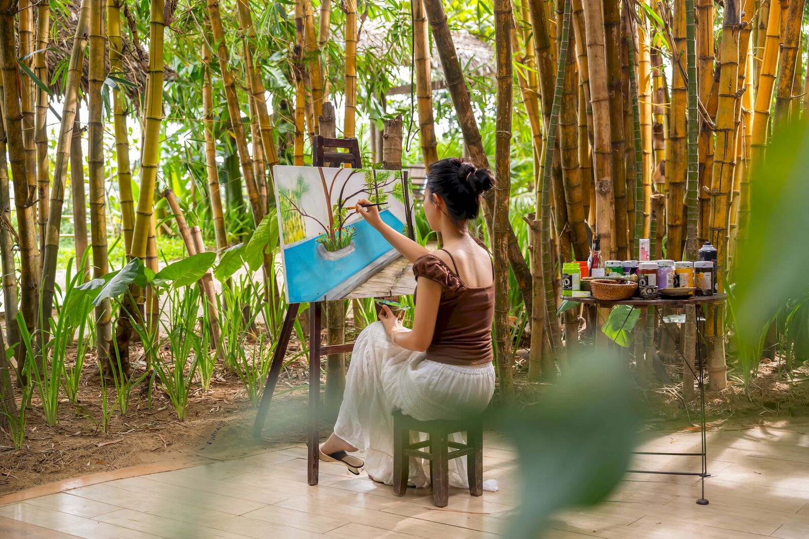 Painting at an easel in the bamboo grove