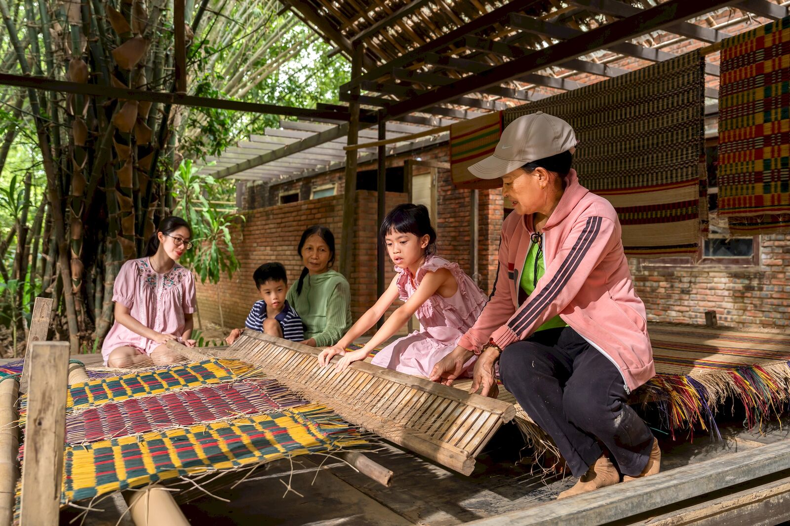Hands guiding the reed through the loom